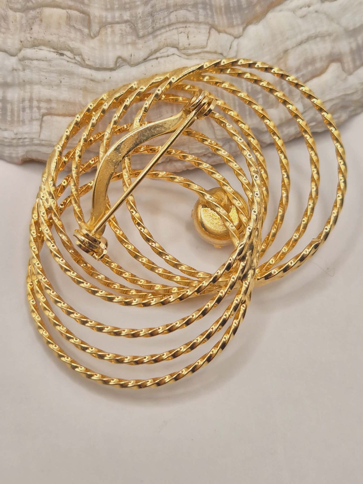 Vintažinė aukso spalvos spiralės sagė su kristalu