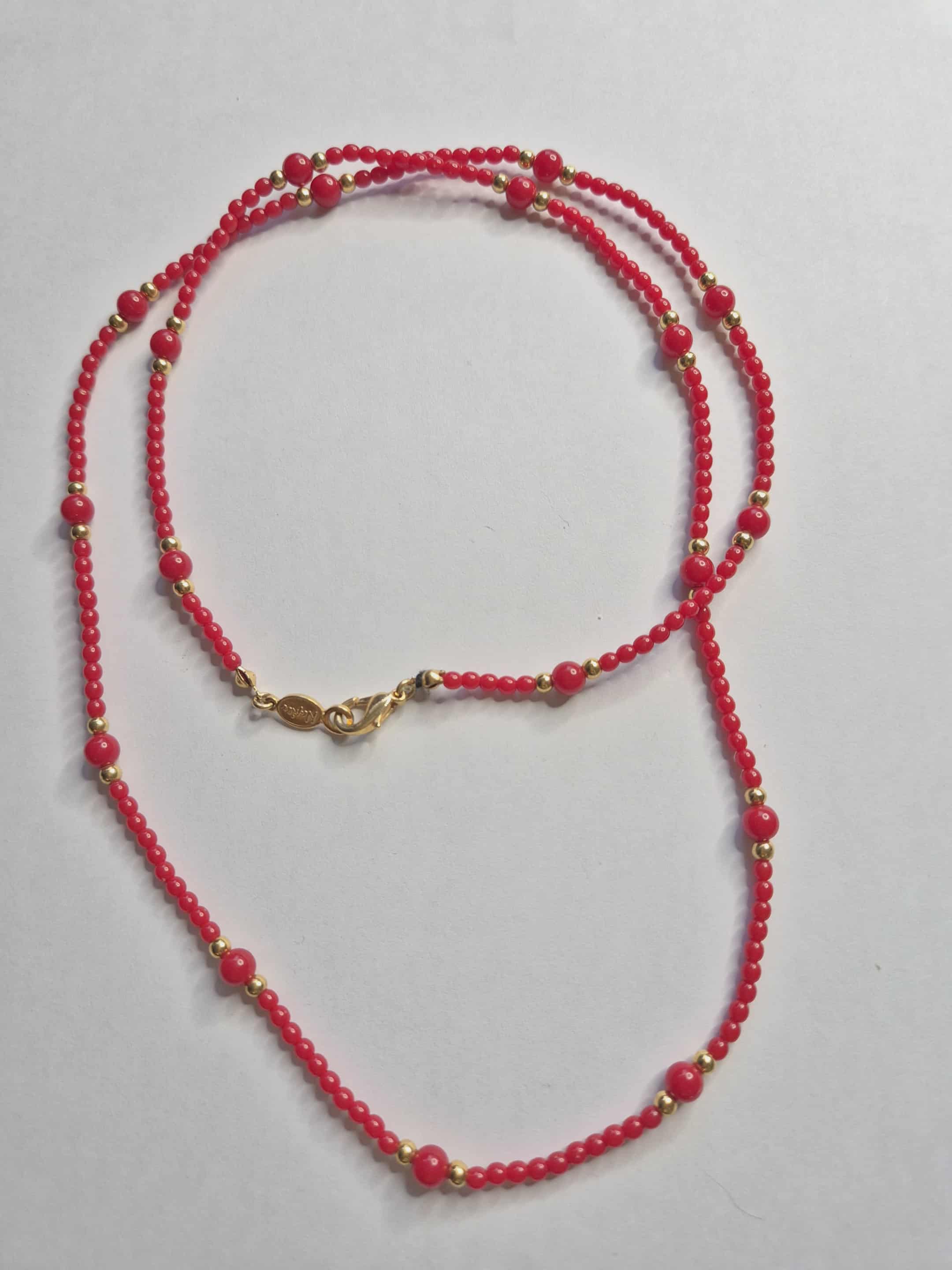 Napier raudoni karoliai su auksinėmis detalėmis