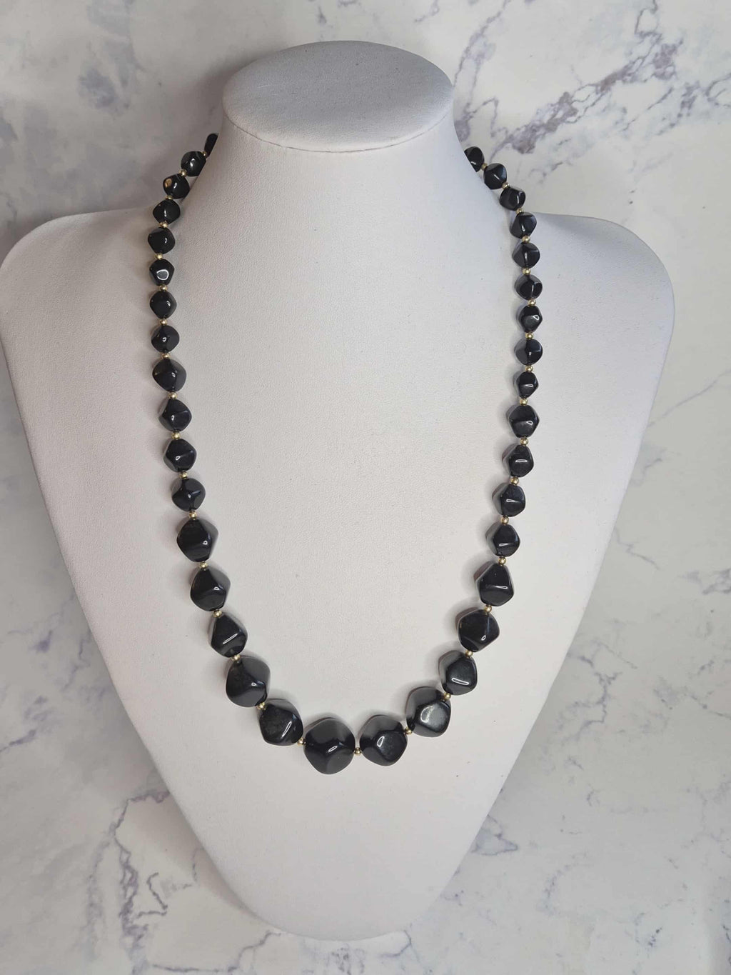 Avon juodi karoliai su auksinėmis detalėmis