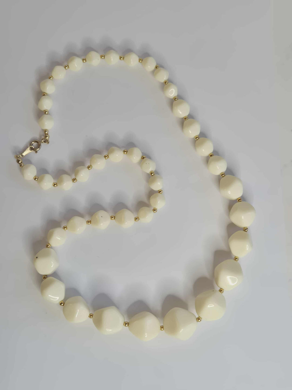 Avon balti  karoliai su auksinėmis detalėmis