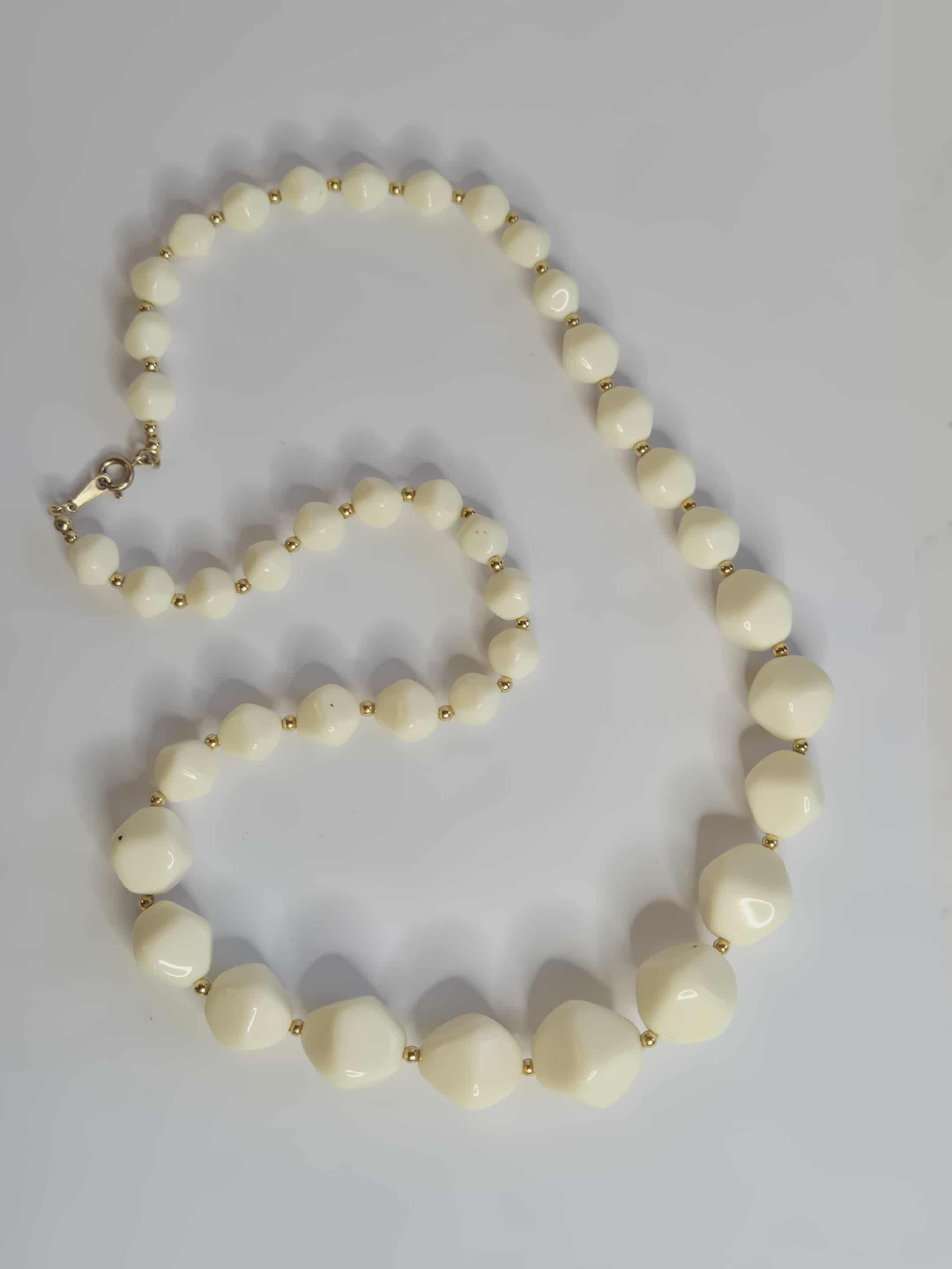 Avon balti  karoliai su auksinėmis detalėmis