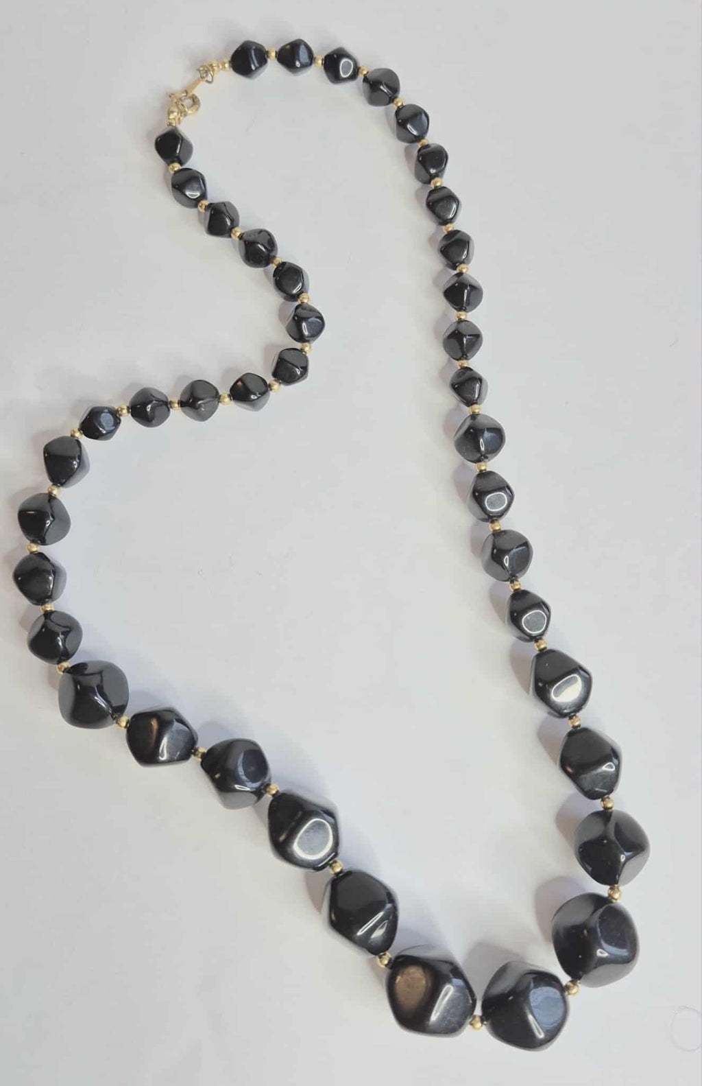 Avon juodi karoliai su auksinėmis detalėmis